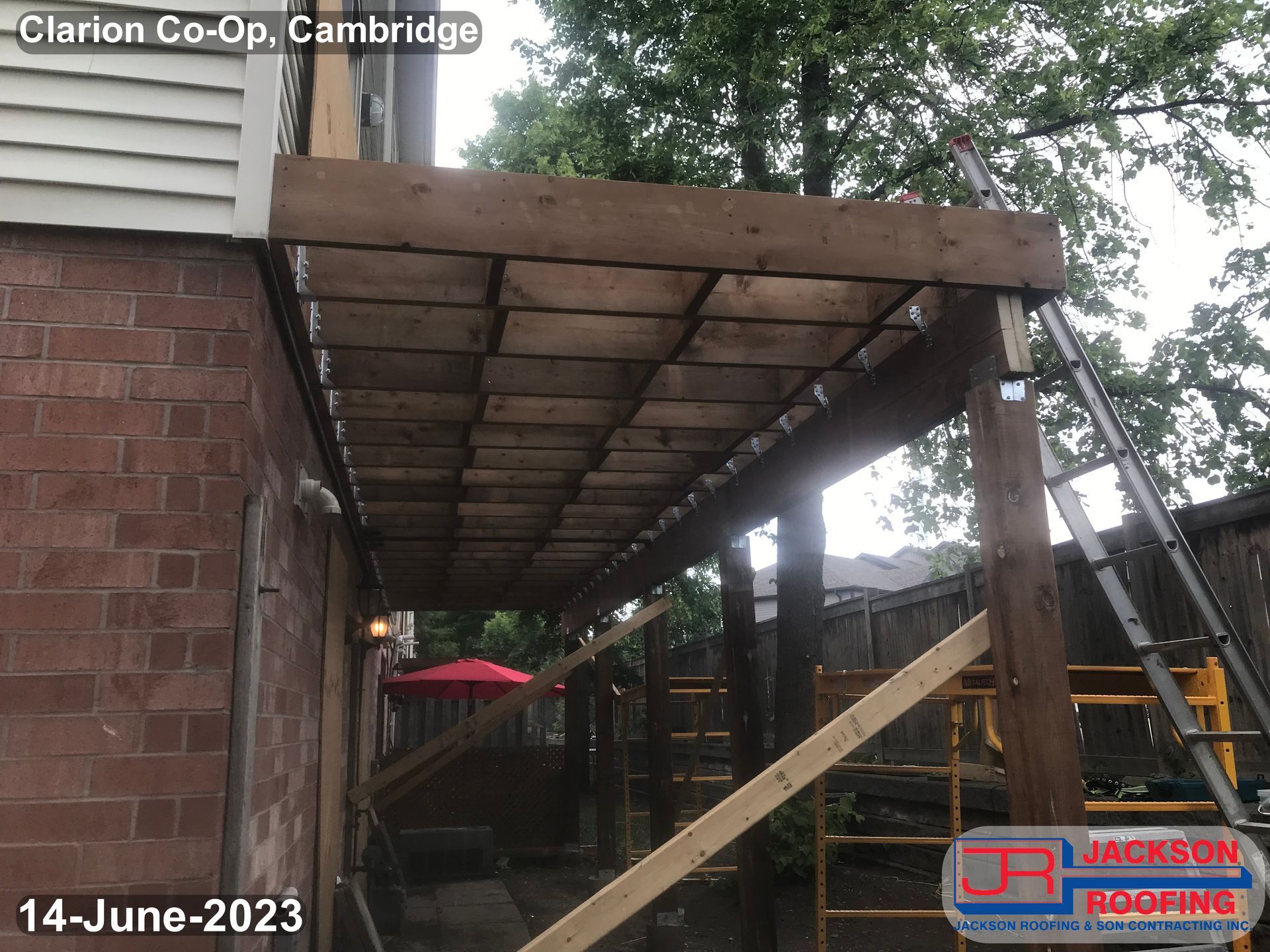 A wooden deck is being built on the side of a house.