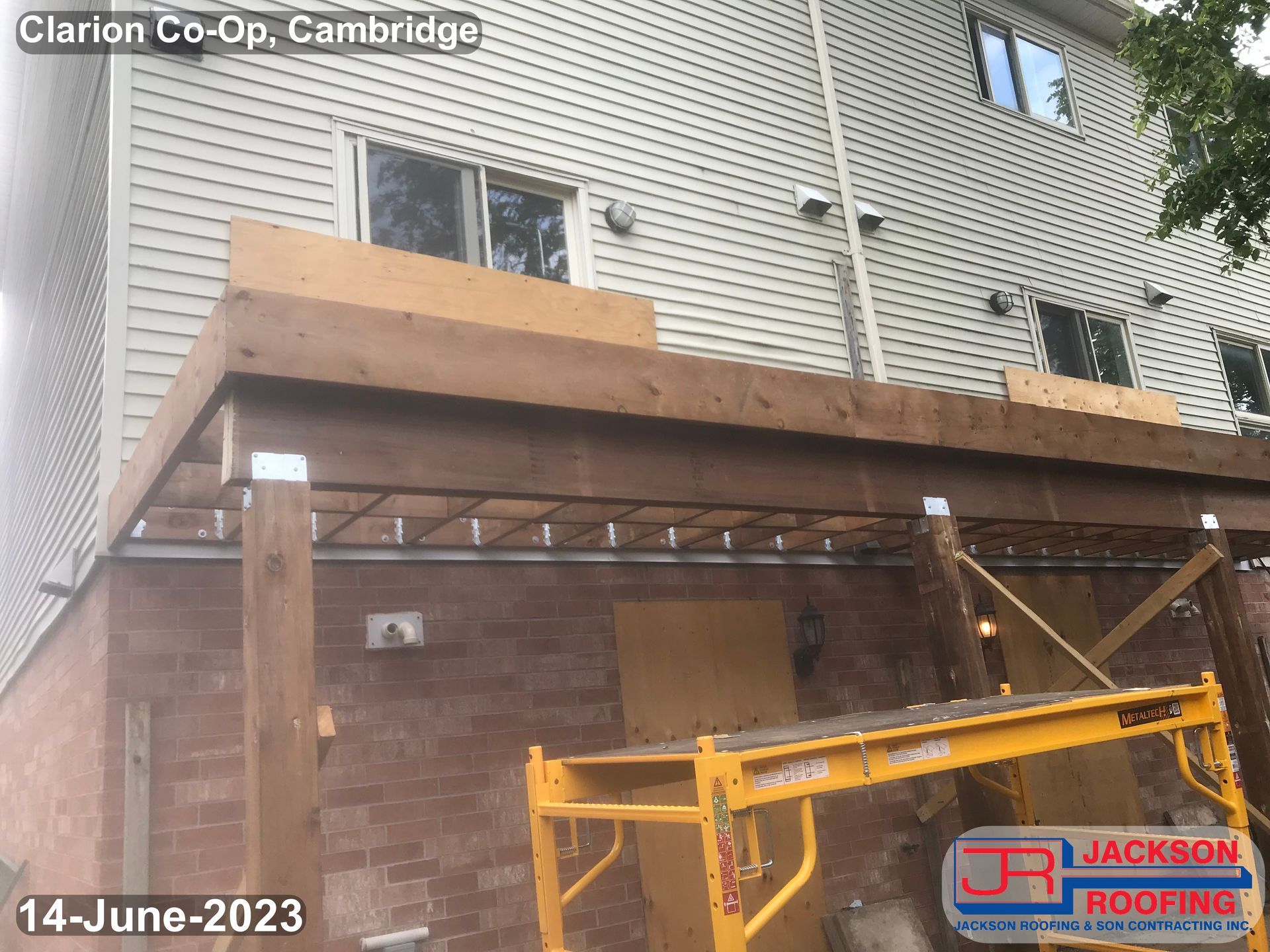 A wooden deck is being built on the side of a house.