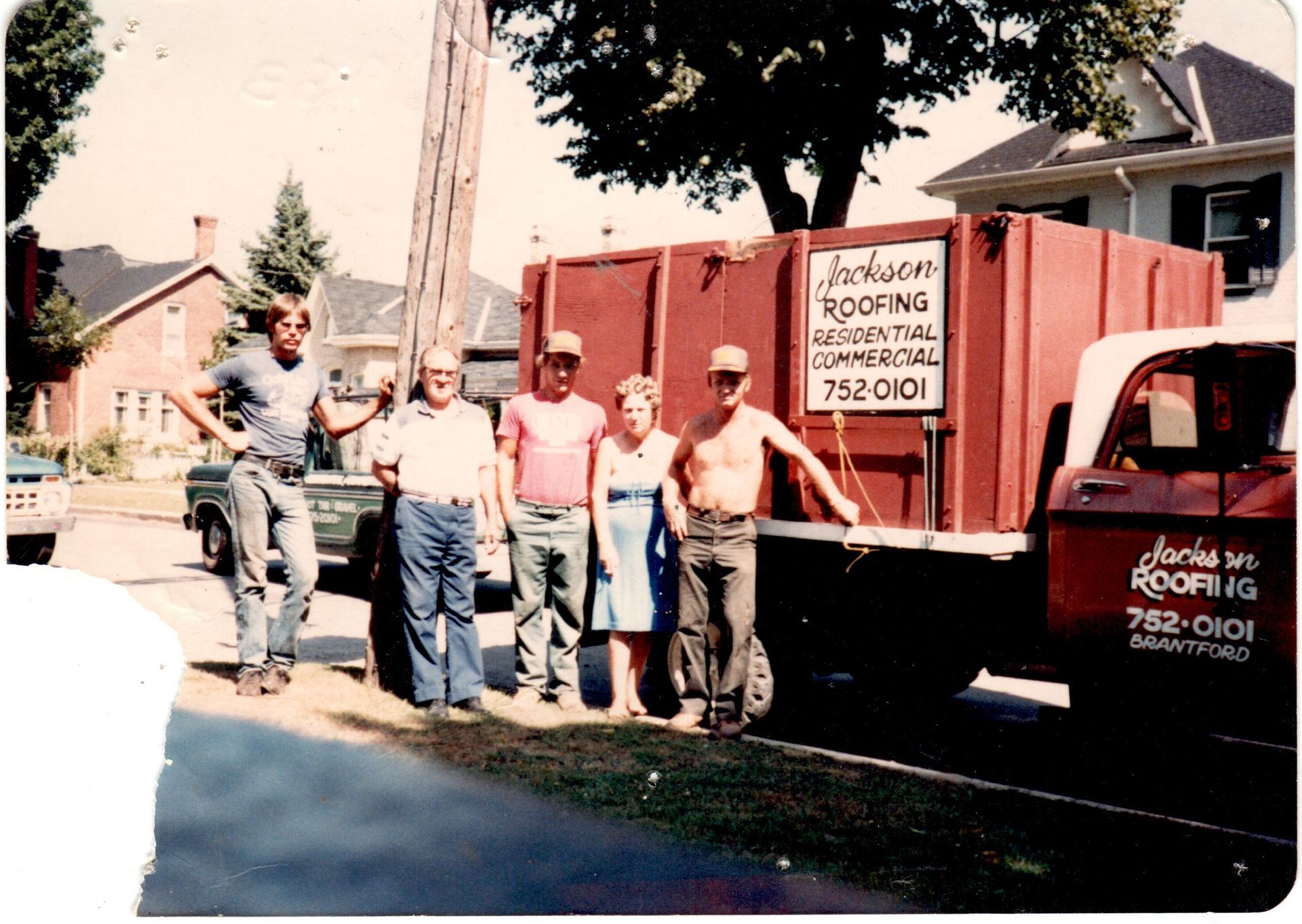 A group of men standing in front of a jackson roofing truck