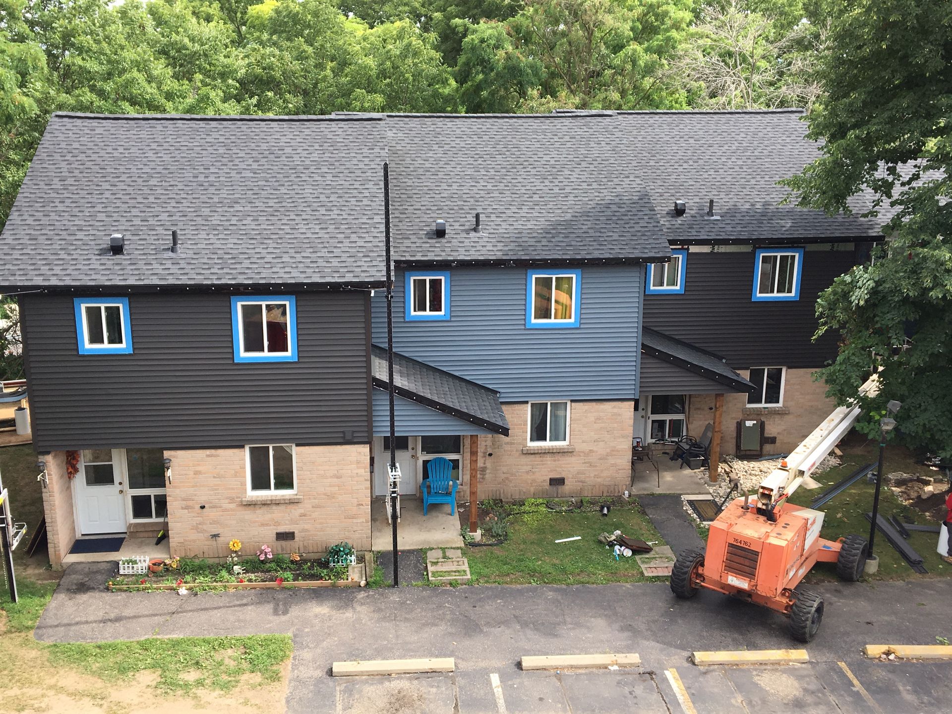 An aerial view of a house with a crane in front of it