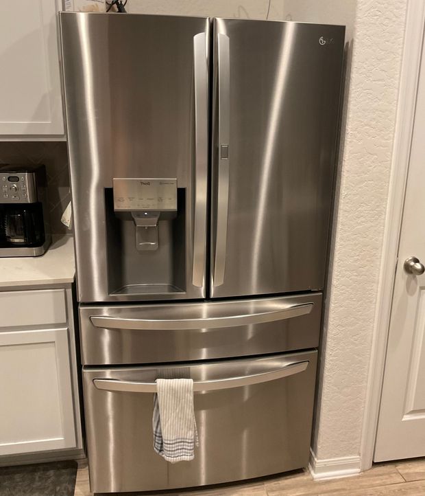 Stainless steel French door refrigerator in a kitchen.