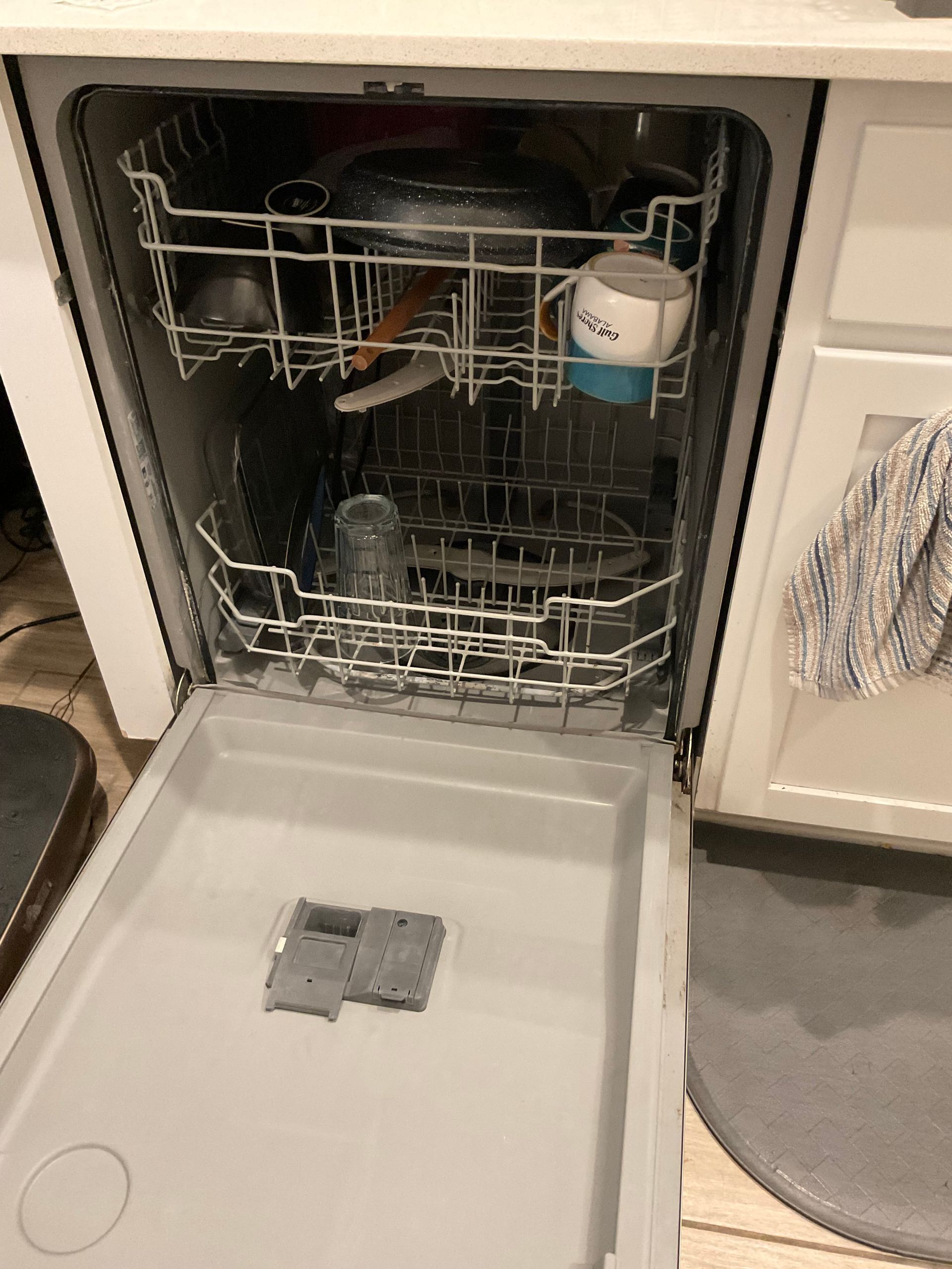 Dishwasher open with dishes inside, gray and white interior.