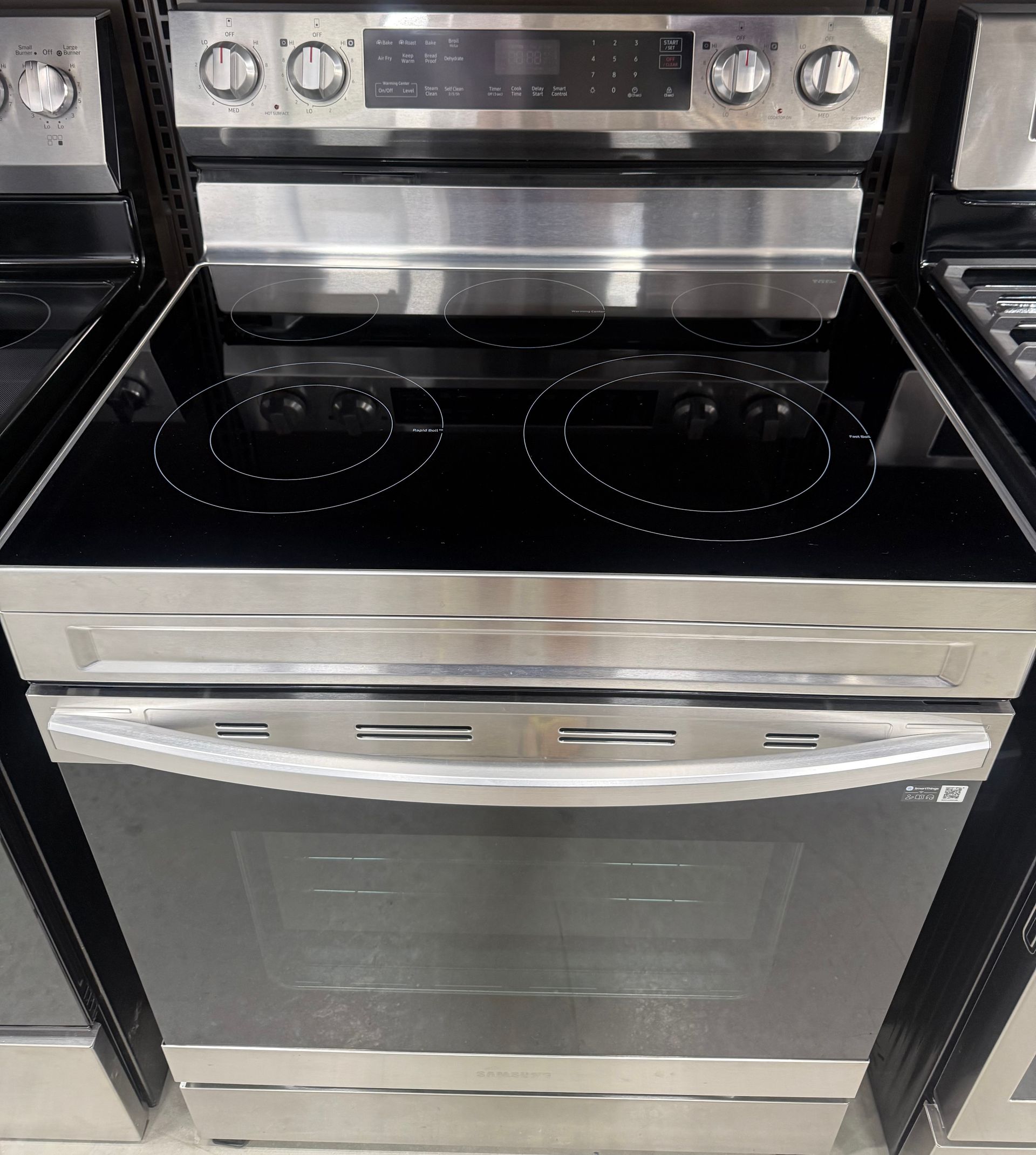 Stainless steel electric range with black glass cooktop and oven.