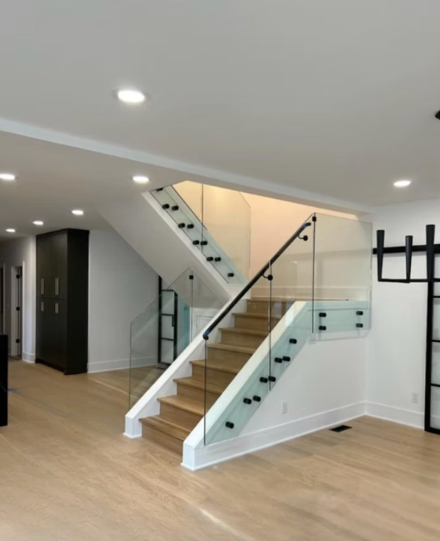 Modern bright interior with wooden stairs and glass railing in an open hallway