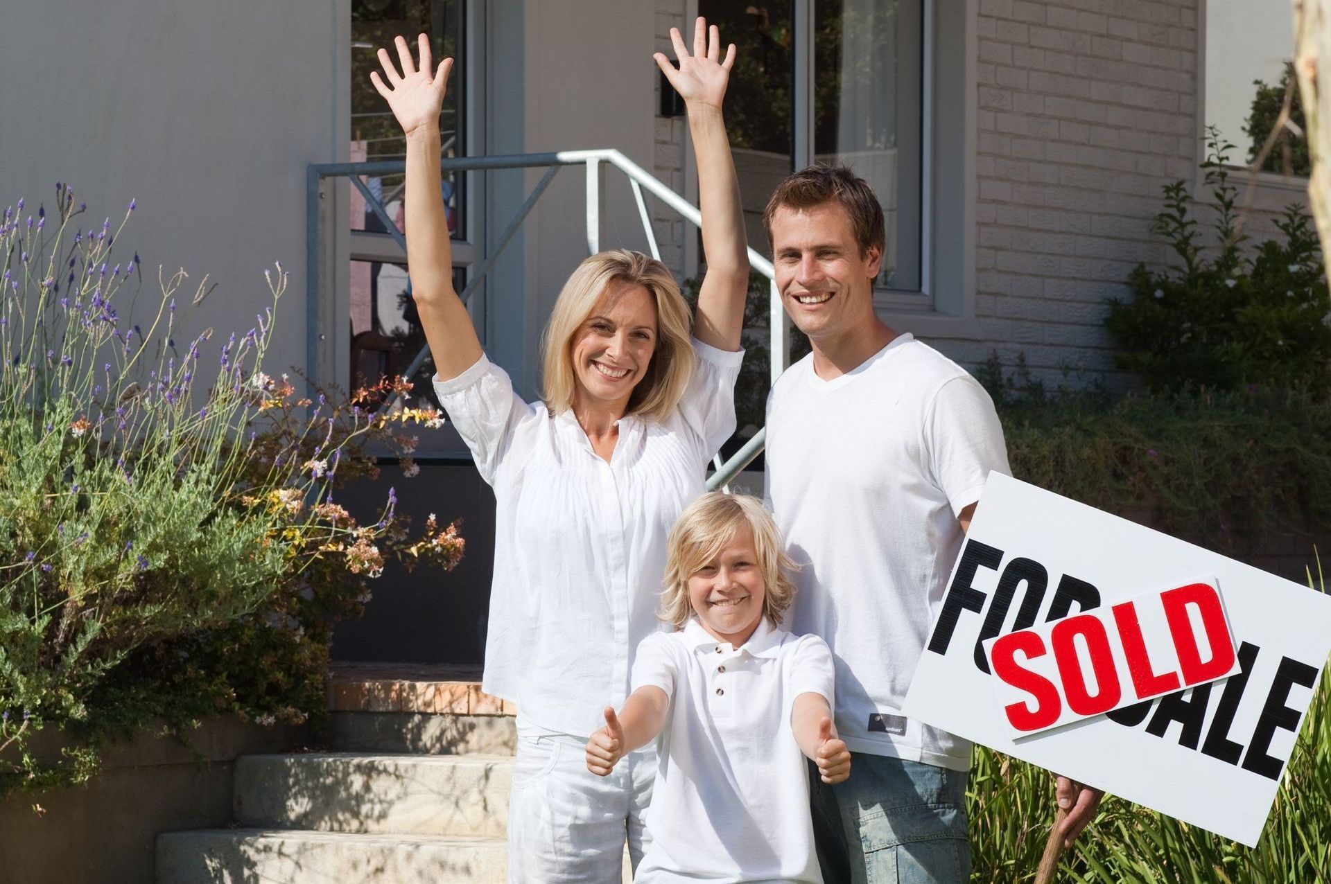 Happy family in front of newly sold house