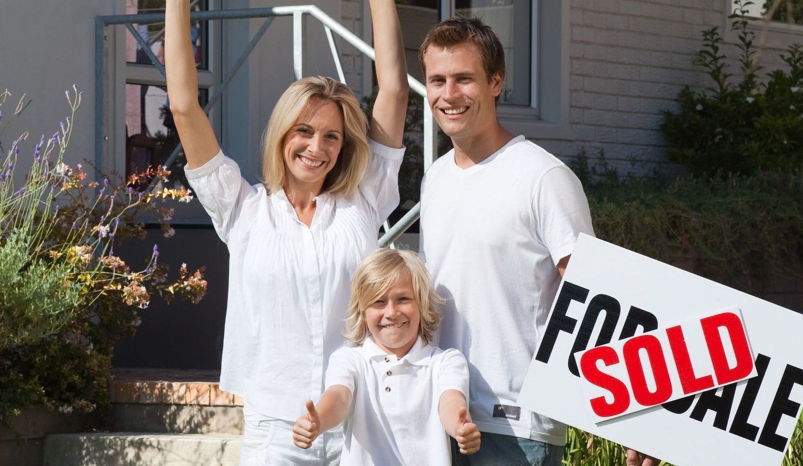 Happy family in front of newly sold house