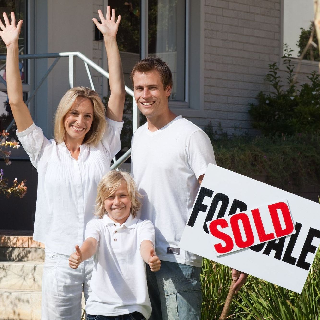 Happy family in front of sold house