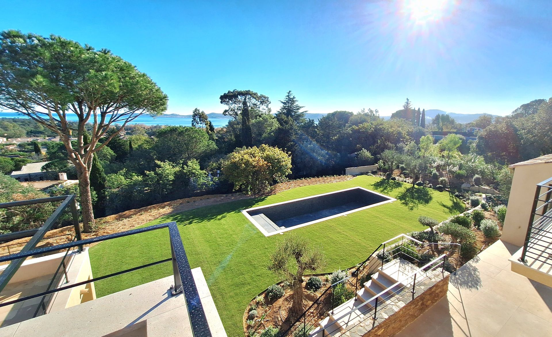 Vue panoramique d'une piscine, d'une pelouse et d'une verdure luxuriante