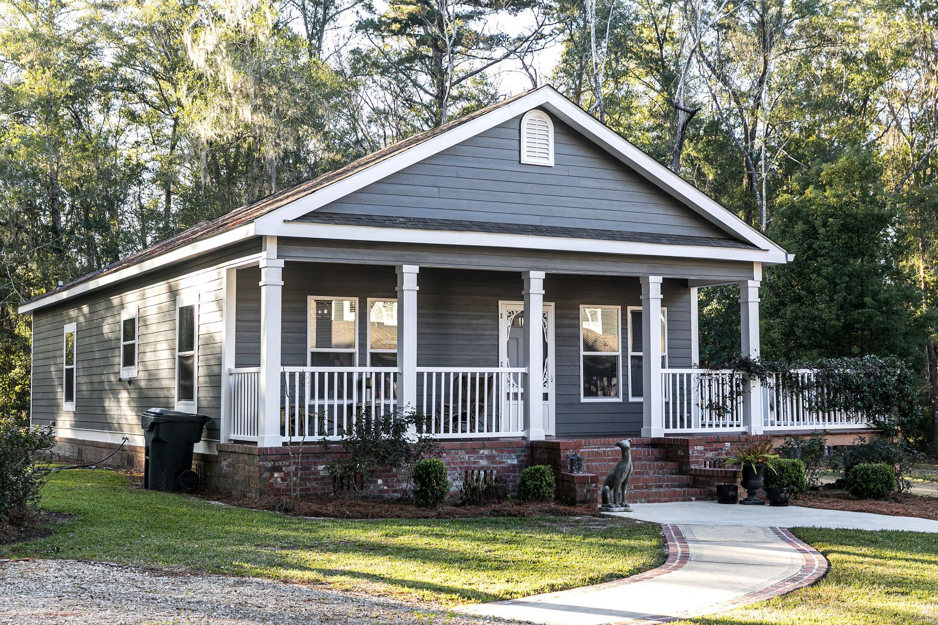 A small house with a porch and a walkway in front of it.