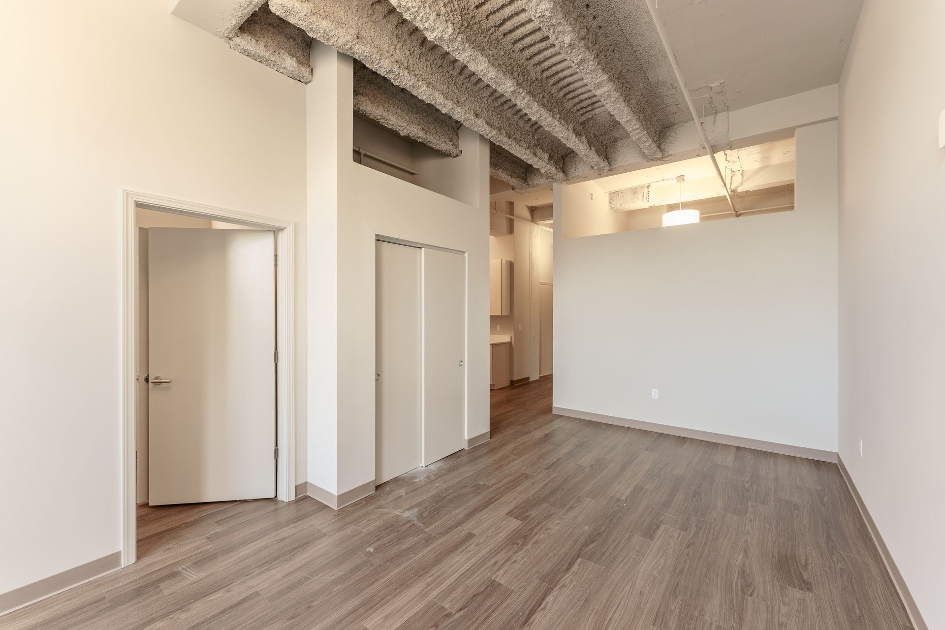 An empty room with hardwood floors and white walls.