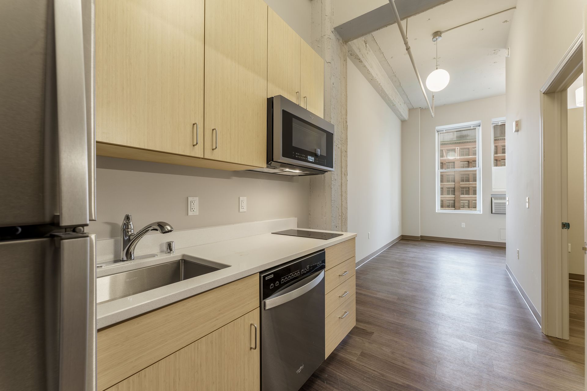 A kitchen with a sink , refrigerator , microwave and dishwasher.