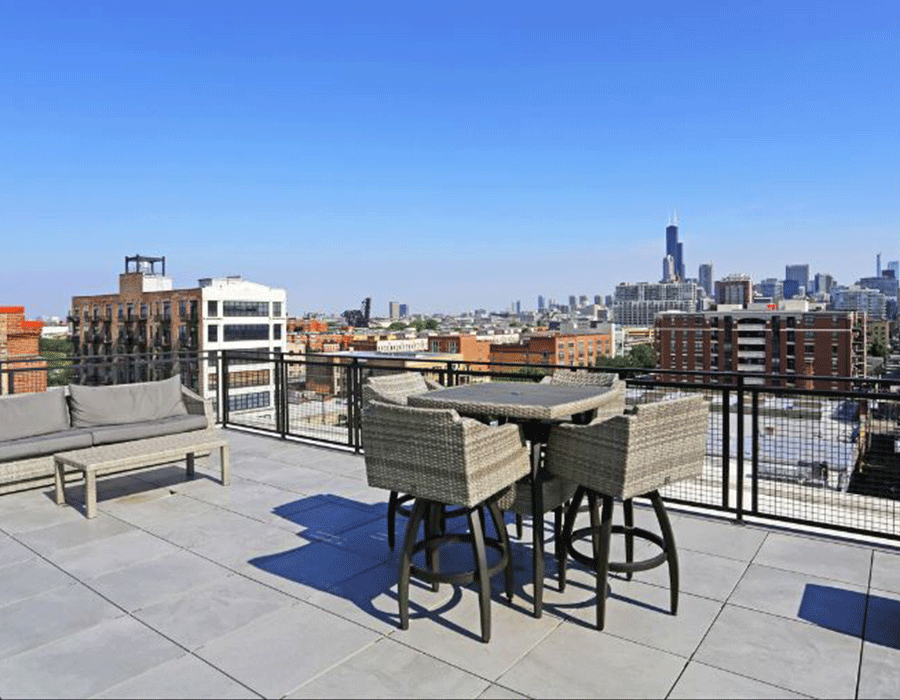 A patio with a table and chairs and a view of the city.