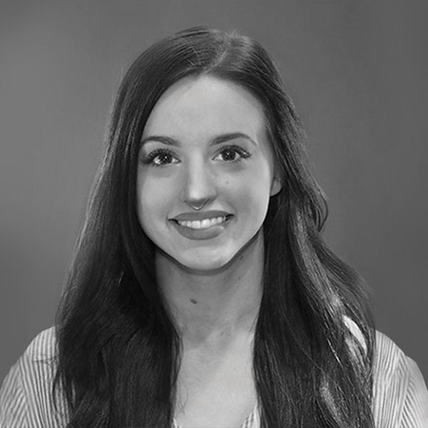 A black and white photo of a woman with long hair smiling.