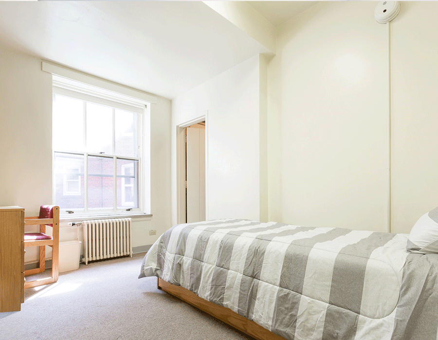A bedroom with a single bed and a window