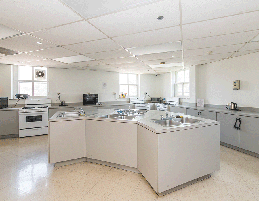 A large kitchen with a stove , sink , and cabinets.
