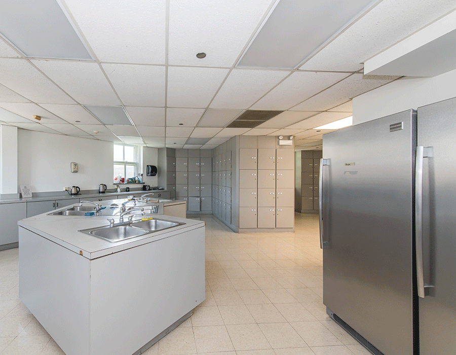 A kitchen with two stainless steel refrigerators and a sink.