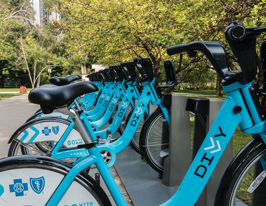 A row of blue diy bikes are parked next to each other