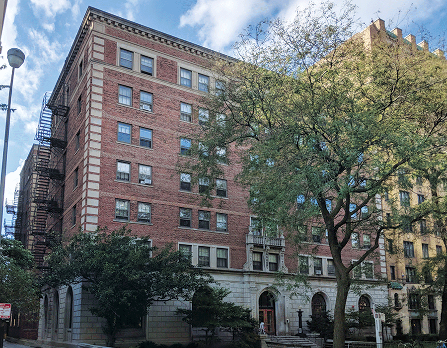 A large brick apartment building with a fire escape on the side of it.