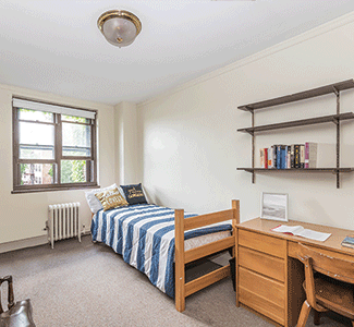 A bedroom with a single bed and a desk