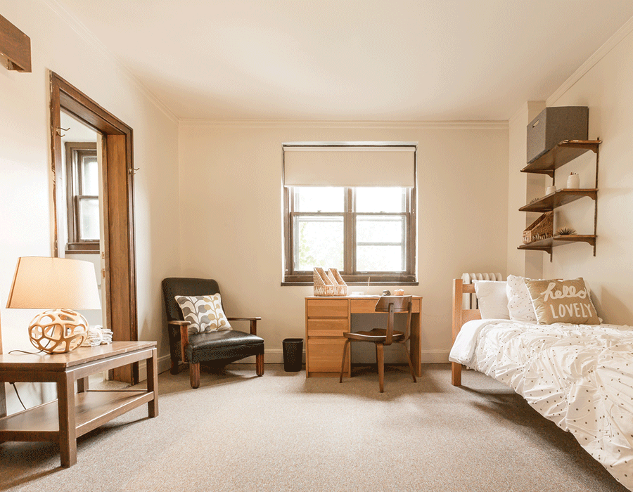 A bedroom with a bed , desk , chair and table.