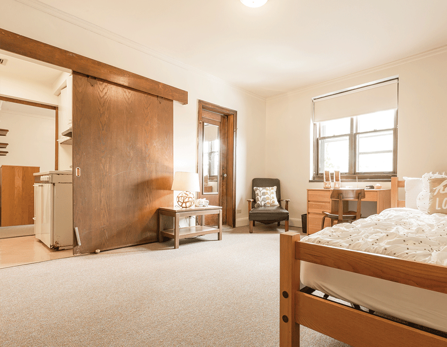 A bedroom with a bed , chair , desk and window.