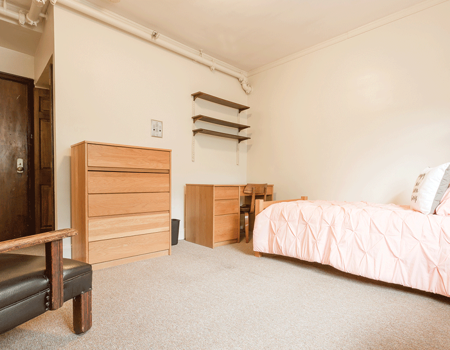 A bedroom with a bed , dresser , desk and chair.