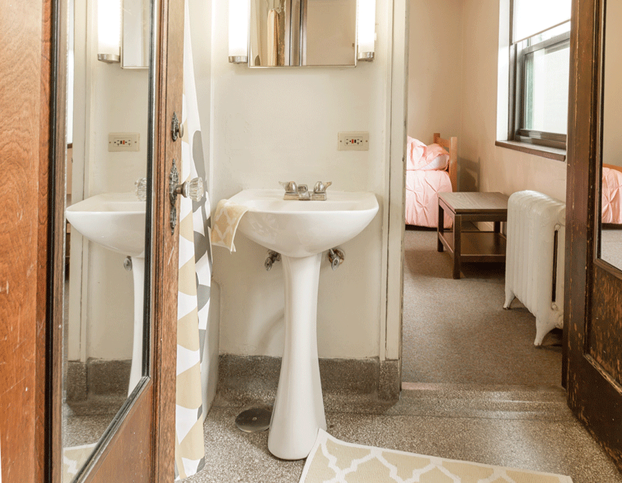 A bathroom with a pedestal sink and a mirror