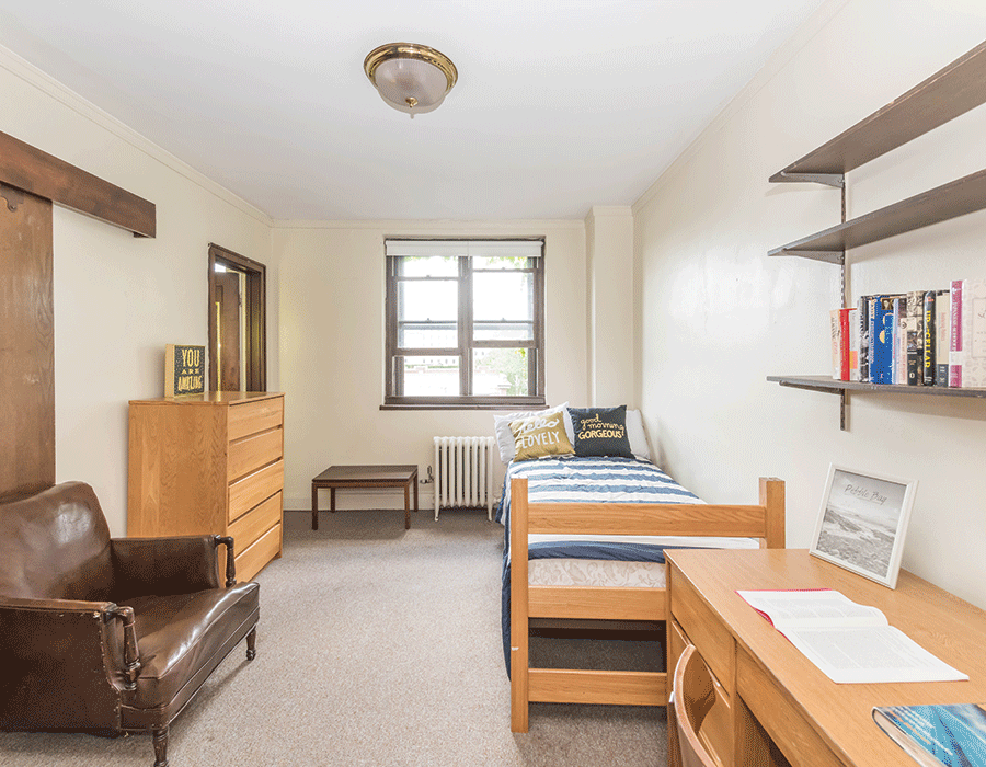 A bedroom with two beds , a desk , a chair and a dresser.