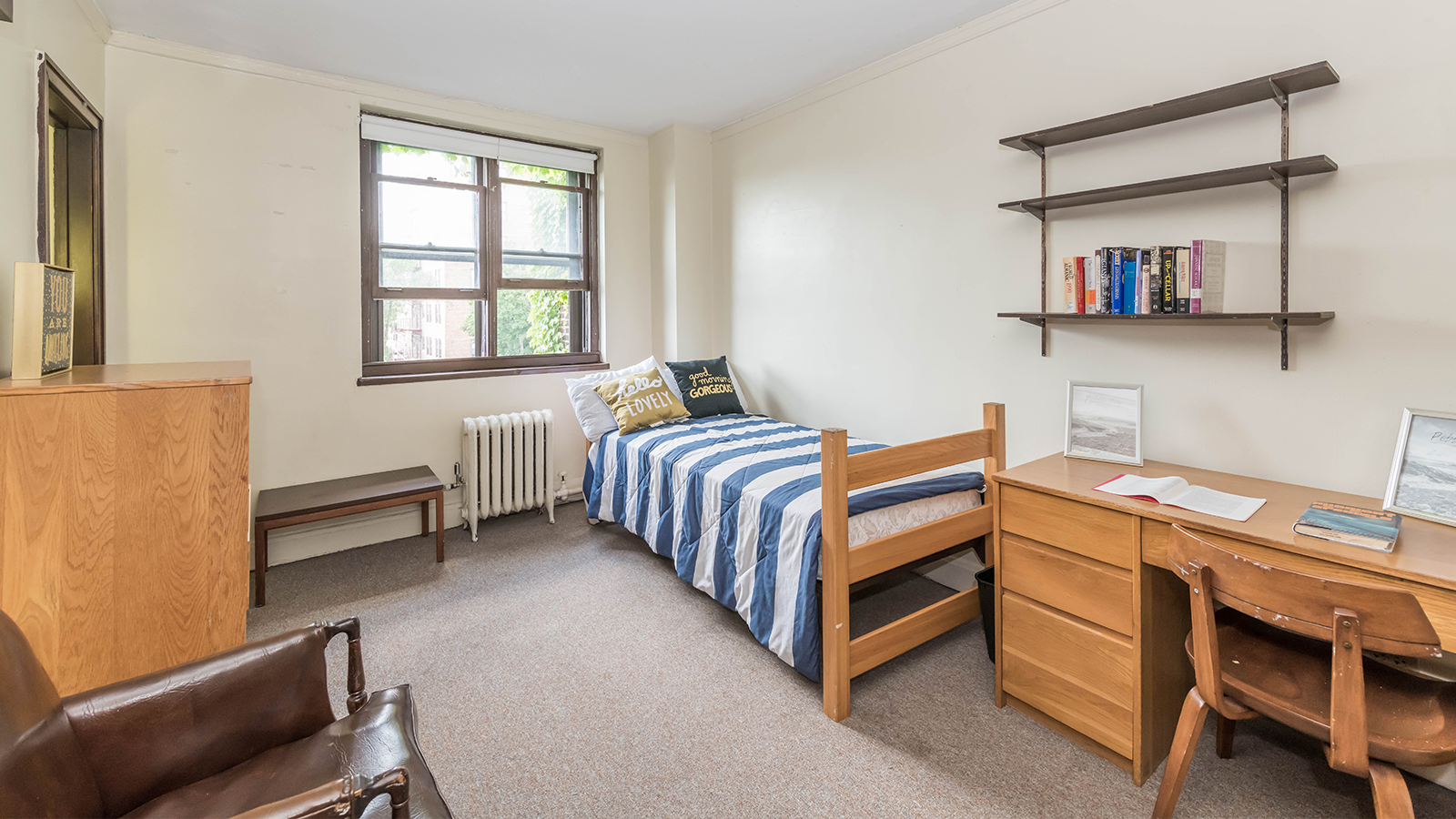 A bedroom with a bed , desk , chair and window.