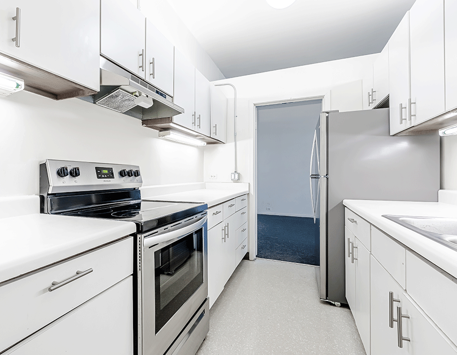 A kitchen with stainless steel appliances and white cabinets