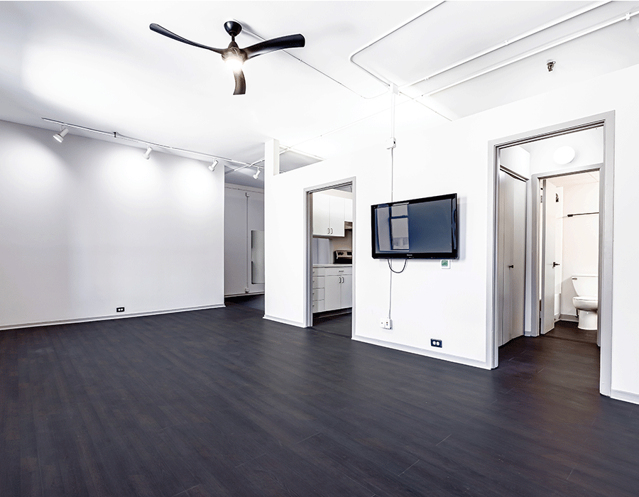 An empty room with a flat screen tv on the wall