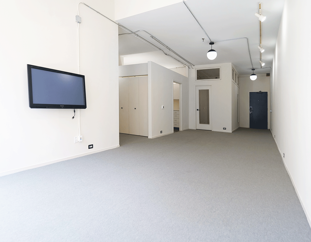 An empty room with a flat screen tv on the wall