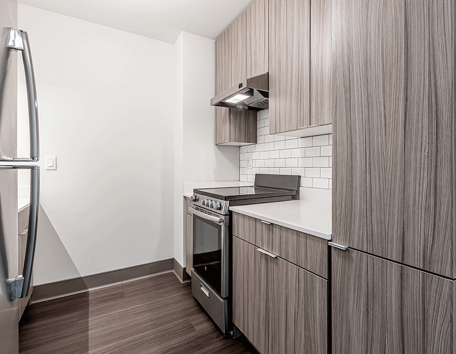 A kitchen with a stove , refrigerator , and cabinets.