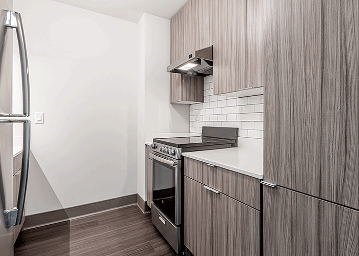 A kitchen with stainless steel appliances and wooden cabinets.