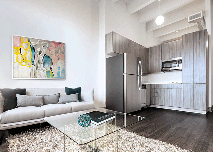 A living room with a couch , coffee table , and refrigerator.