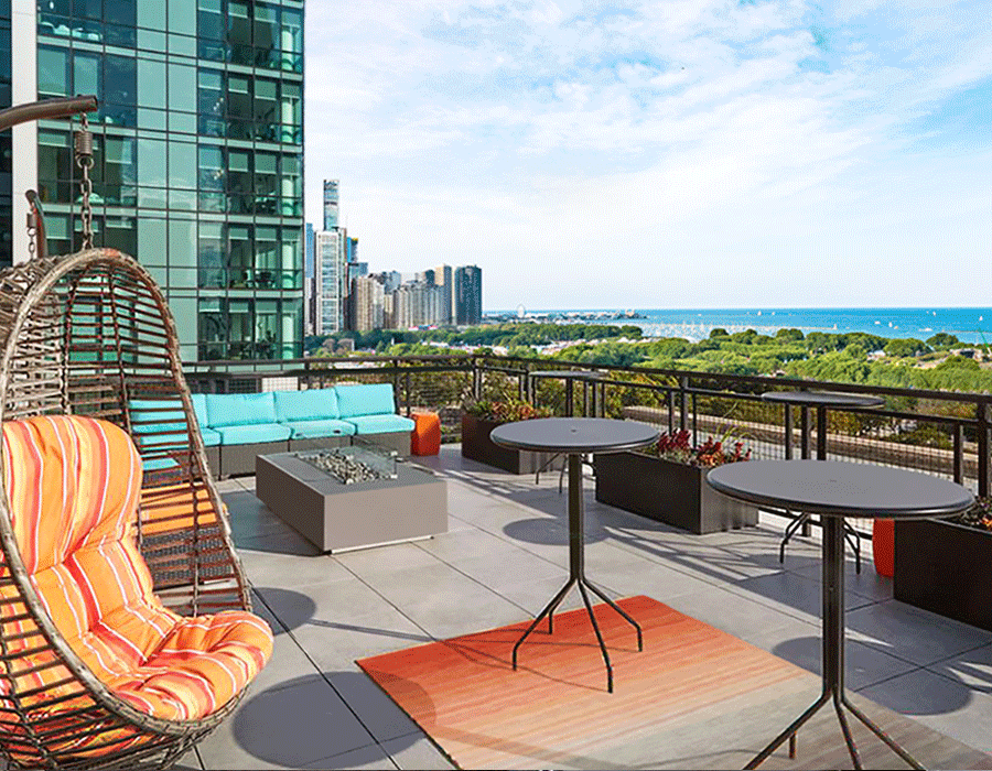 A patio with tables and chairs and a view of the city