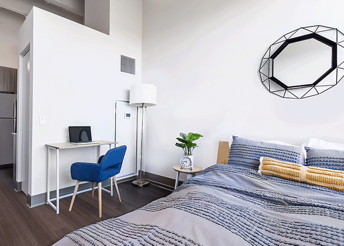 A bedroom with a bed , desk and chair.