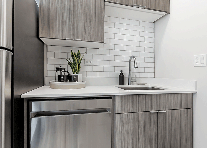 A kitchen with stainless steel appliances , a sink , a refrigerator , and a dishwasher.