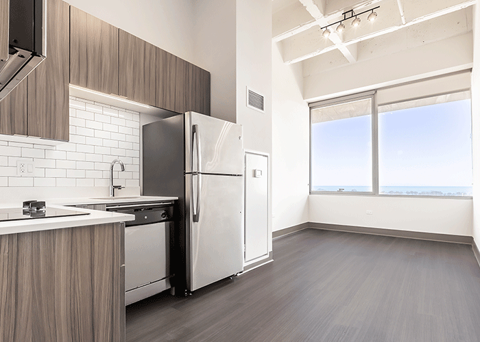 A kitchen with a refrigerator , dishwasher , sink , and large window.