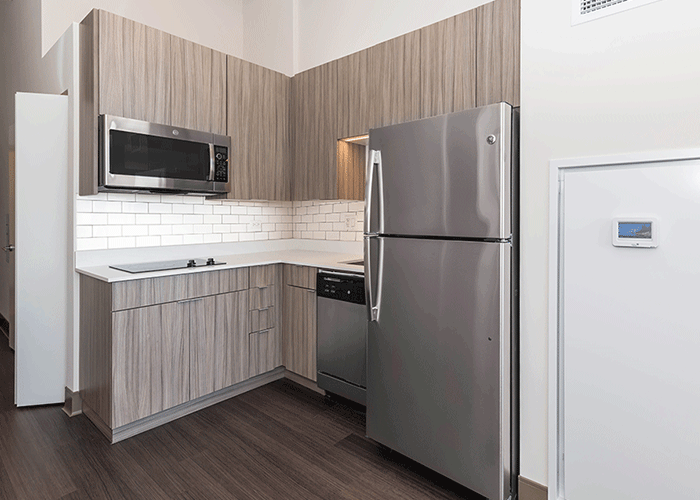 A kitchen with stainless steel appliances and wooden cabinets.
