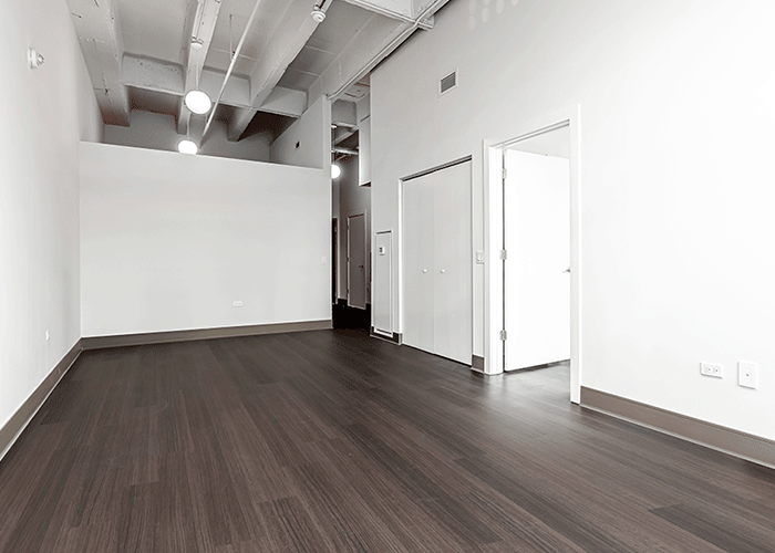 An empty room with a wooden floor and white walls.