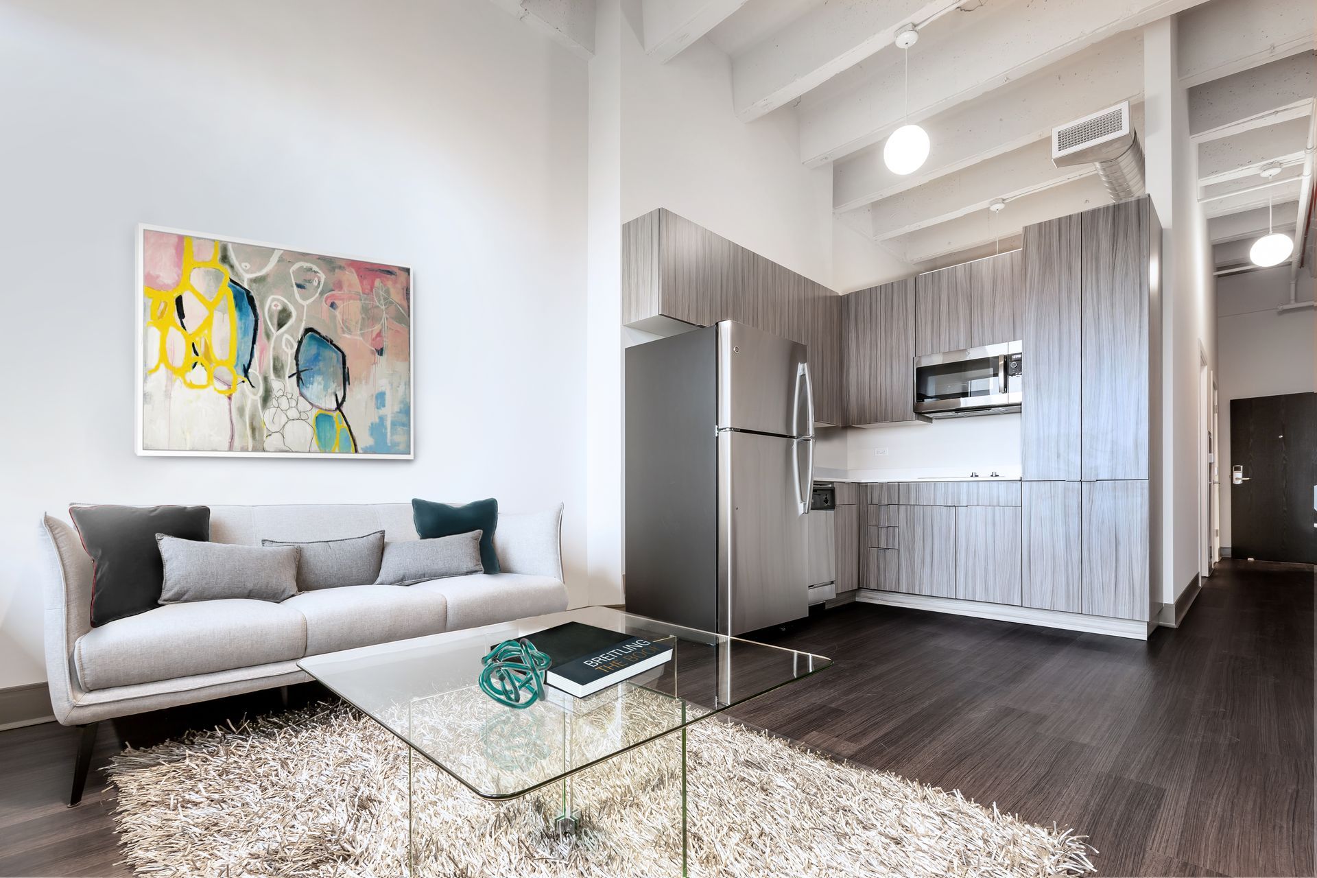 A living room with a couch , coffee table , and refrigerator.