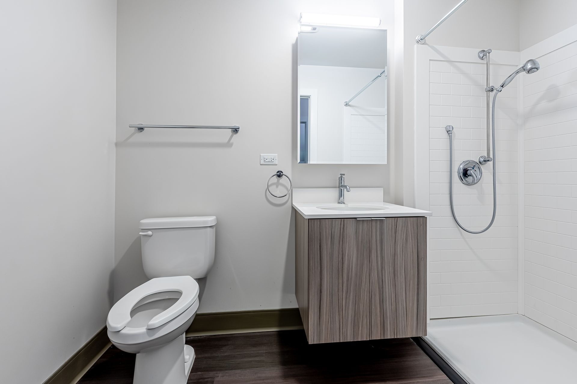 A bathroom with a toilet , sink and shower.