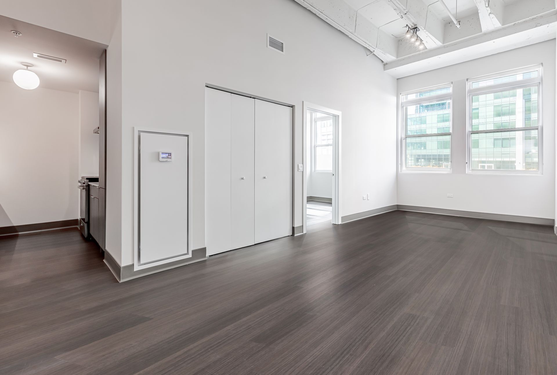 A large empty room with hardwood floors and white walls.