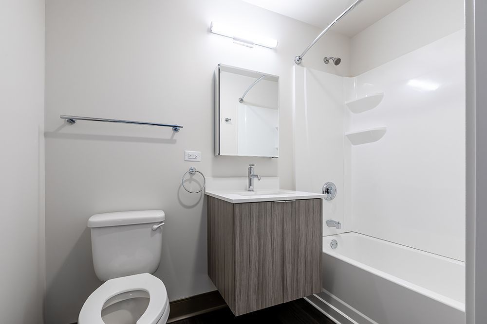 A bathroom with a toilet , sink , and bathtub.
