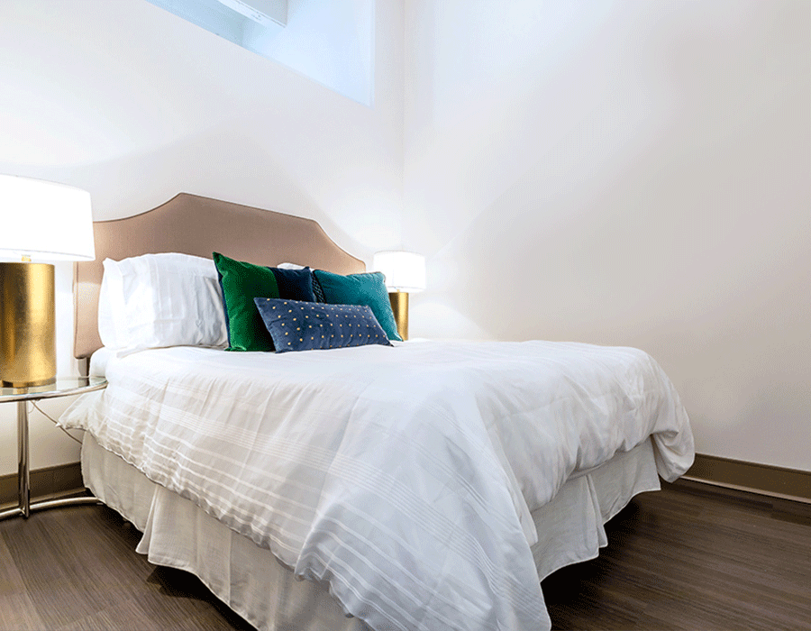 A bedroom with a king size bed and two lamps.