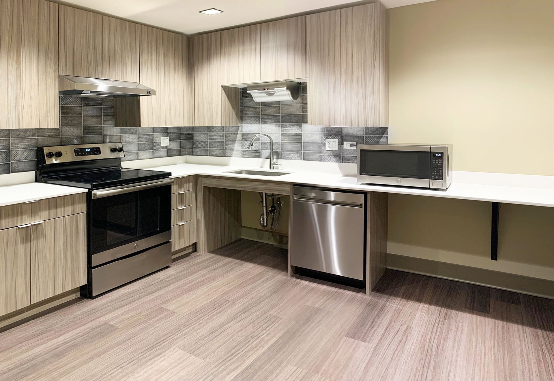 A kitchen with stainless steel appliances and wooden cabinets.