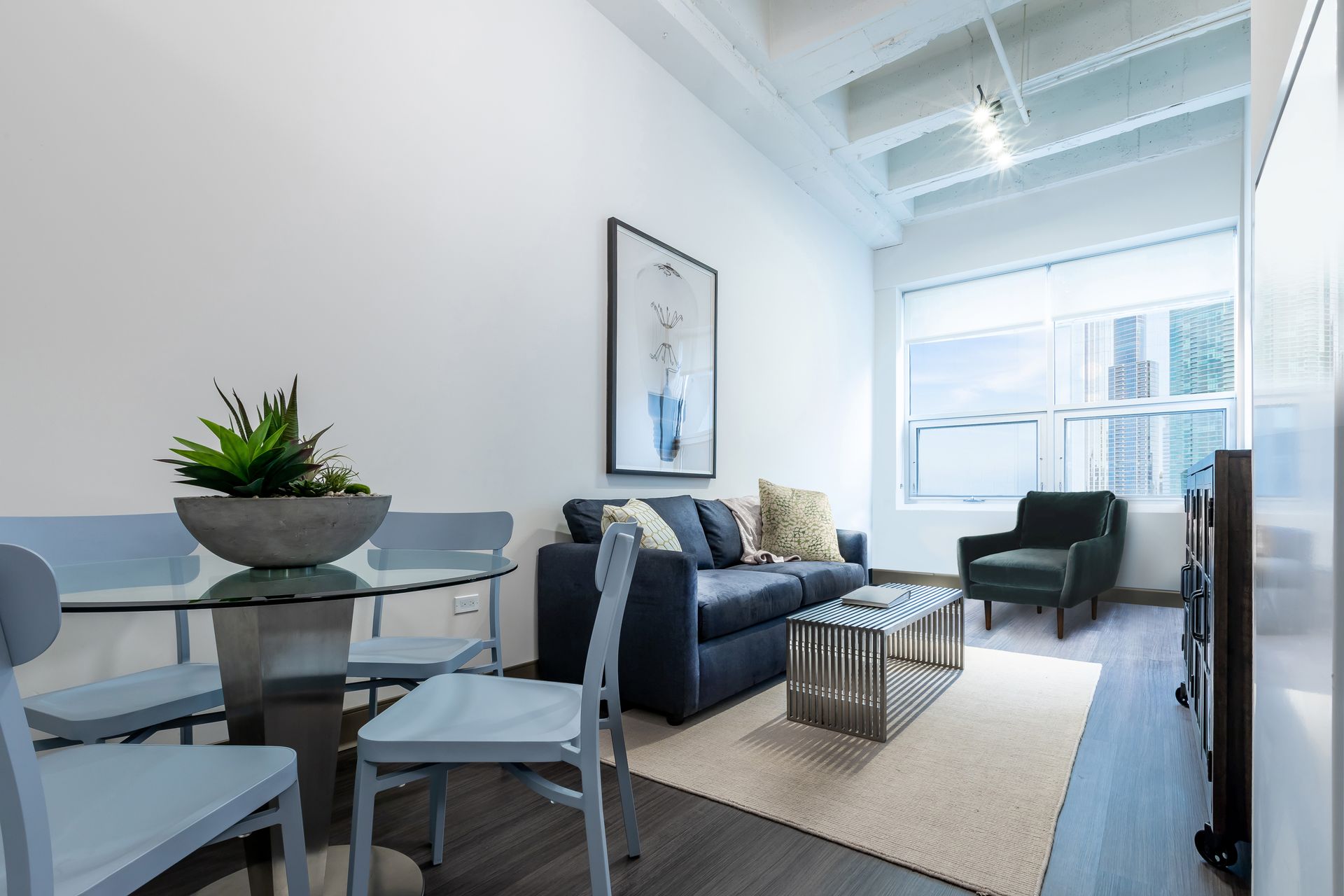 A living room with a couch , table and chairs