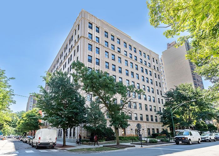 A large building is sitting on the corner of a city street.