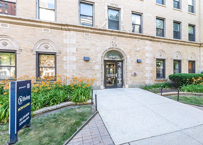 A large brick building with a concrete walkway leading to the entrance.